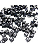 Letra blanca. Cubo negro. 6 milímetros lado. 3 milímetros perforación. 100 uds aproximado.