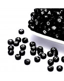 Letra blanca. Moneda negra. 7 milímetros diámetro. 1,5 mm perforación. 100 unidades aproximado.