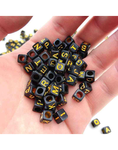Letra dorada. Cubo negro. 6 milímetros lado. 3 mm perforación. 100 unidades aproximado.
