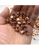 Letra color cobre. Cubo color cobre. 6 milímetros lado. 3 mm perforación. 100 unidades aproximado.