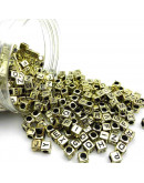 Letra negra. Cubo dorado. 6 milímetros lado. 3 mm perforación. 100 unidades aproximado.