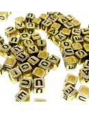 Letra negra (vocales). Cubo dorado. 6 milímetros lado. 3 mm perforación. 100 unidades aproximado.
