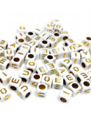 Letra dorada (vocales). Cubo blanco. 6 milímetros lado. 3 mm perforación. 100 unidade aproximado.