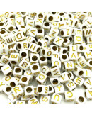 Letra dorada. Cubo blanco. 6 milímetros lado. 3 mm perforación. 100 uds aproximado.