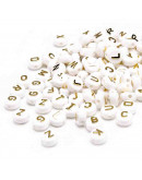 Letra dorada. Moneda blanca. 10 milímetros diámetro. 2,5 mm perforación. 50 unidades aproximado.