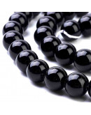 Piedra sintética. Negro brillante. 04 mm diámetro. 0,8 mm perforación. 90 unidades hilo (aproximado)