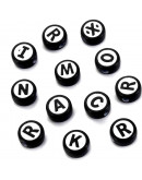 Letra negra. Moneda blanca/negra. 10 milímetros diámetro. 2 mm perforación. 50 unidades (aprox).