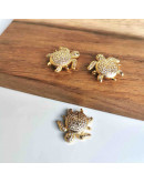 Tortuga. Aleación+Zirconia. Baño 18K Gold. 20x18x5 milímetros. 1,2 mm perforación. 1 unidad. Tortuga. Aleación+Zirconia. Baño 18K Gold. 20x18x5 milímetros. 1,2 mm perforación. 1 unidad.